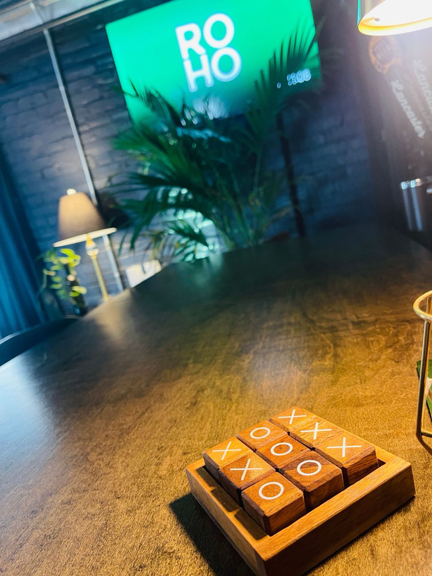 Wooden tic-tac-toe game on a table at ROHO